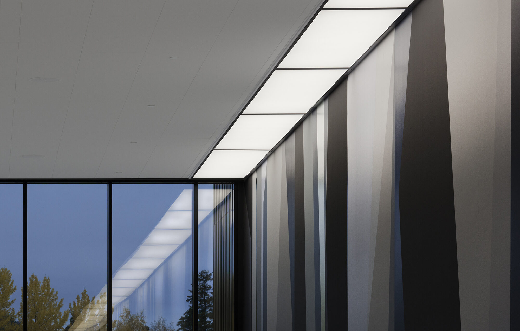 Kunstverket forener ute og inne med et 50x5 meter langt veggmaleri i foajeen og ute på plassen foran bygget.