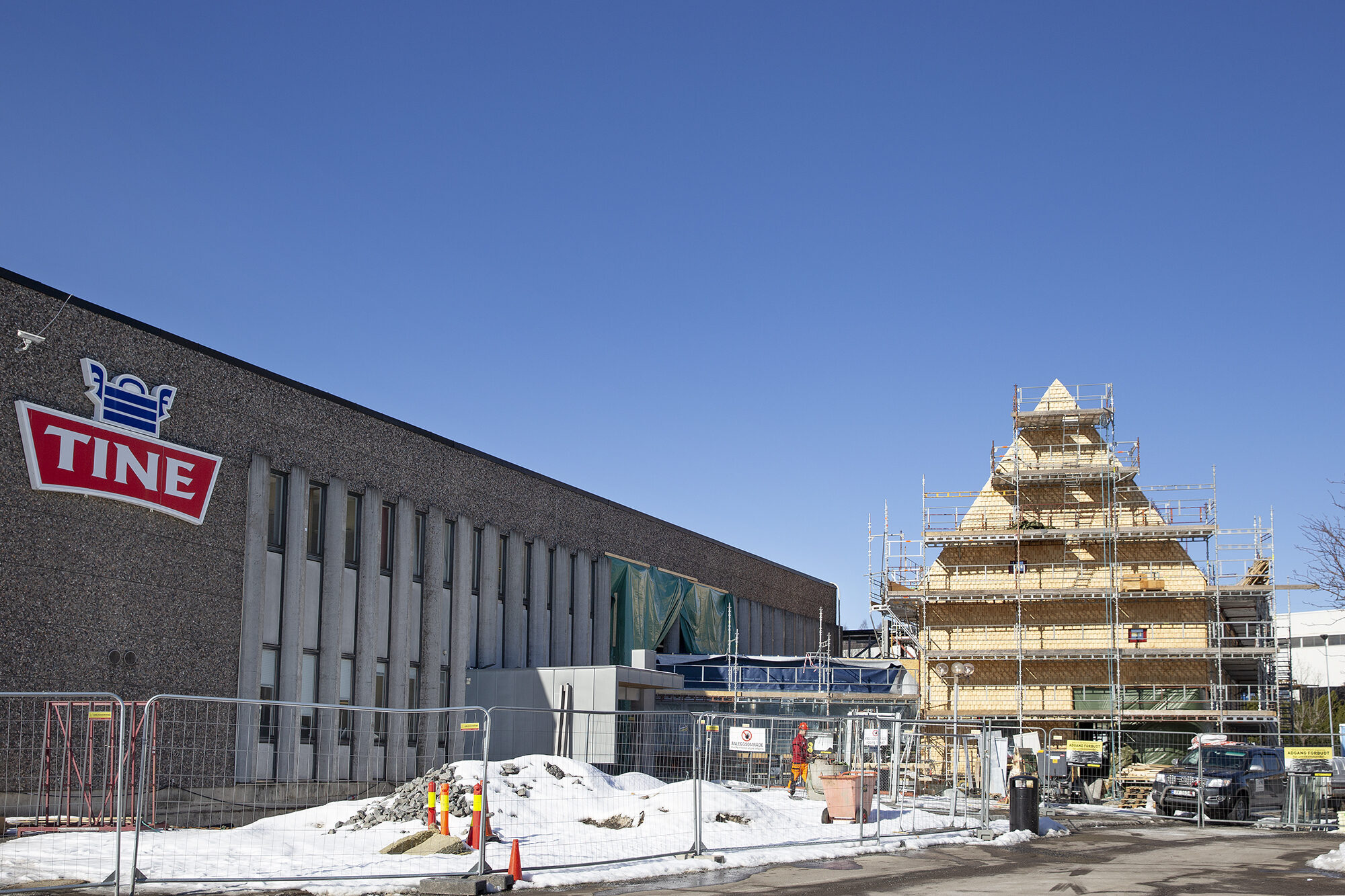 Den nye adkomstpaviljongen er utformet med inspirasjon fra låvemotivet i et område som ellers er preget av industri og tunge trafikksystemer.